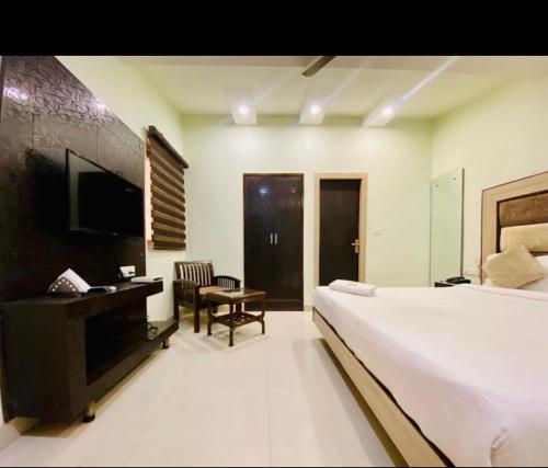 une chambre avec un lit, un bureau et une télévision dans l'établissement Hotel November 1 Min from Zirakpur bus stand, à Zirakpur