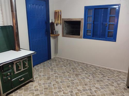 une cuisine avec des portes bleues et un sol carrelé dans l'établissement Sossego na Serra Catarinense - Casa em Lages, à Lages