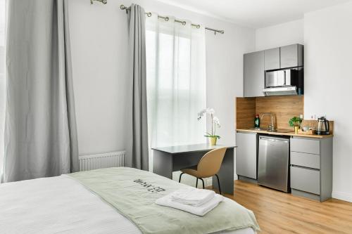 a bedroom with a bed and a desk and a kitchen at West Bridgford Comfort Quality Suites in Nottingham