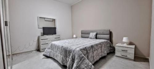 a bedroom with a bed and a dresser and a tv at La Dimora del Colle in Palo del Colle
