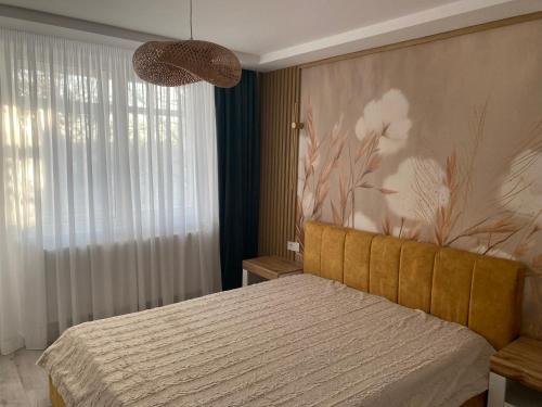 a bedroom with a bed with a flower mural on the wall at Central Nest in Tecuci