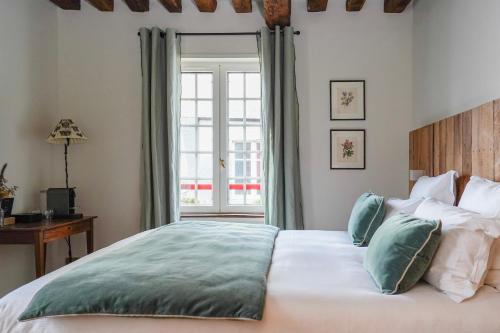 ein Schlafzimmer mit einem großen Bett und einem Fenster in der Unterkunft L'Absinthe Hôtel in Honfleur