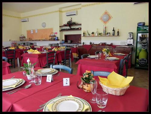 a restaurant with red tables and chairs with red table cloths at Hotel Eros in Lido di Camaiore
