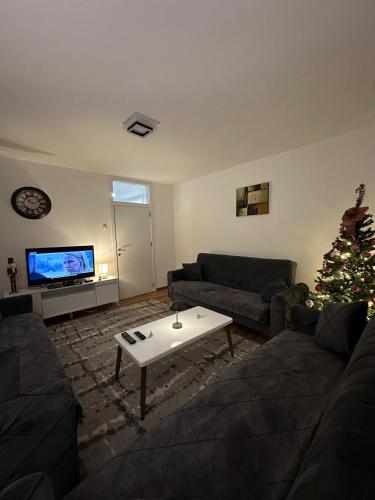 a living room with a christmas tree and a couch at Veneto Apartment in Prishtinë