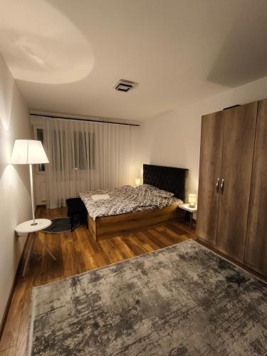 a bedroom with a bed and a table and a lamp at Veneto Apartment in Prishtinë