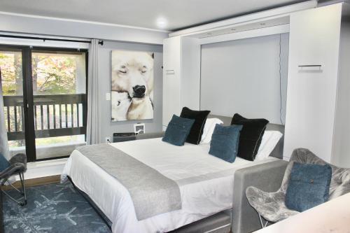 a bedroom with a large bed with a picture of a dog at Ski Condo with Garage Parking and Pool in Killington