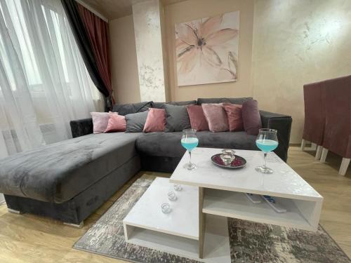 un soggiorno con divano e 2 bicchieri da vino di La Montana 3 a Zlatibor