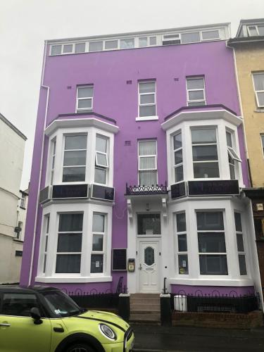 a purple house with a car parked in front of it at Wilsons Lodge in Blackpool