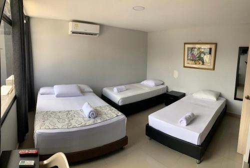 een kamer met drie bedden in een kamer bij Hotel Prado 53 in Barranquilla