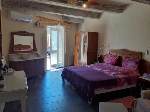 sypialnia z fioletowym łóżkiem i lustrem w obiekcie Dar ta'Zeppi Mansion w mieście Qala