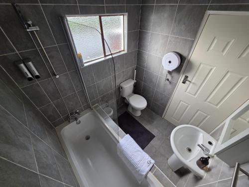 une salle de bains avec baignoire, toilettes et lavabo dans l'établissement Casa-Pel Guest Wing, à Palatswe