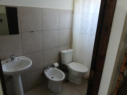 a bathroom with a toilet and a sink at Altos de el bolson in El Bolsón