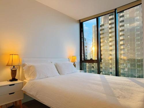 a bedroom with a white bed and a large window at Prospect Box Hill - Magnificent View 2B1B in Box Hill