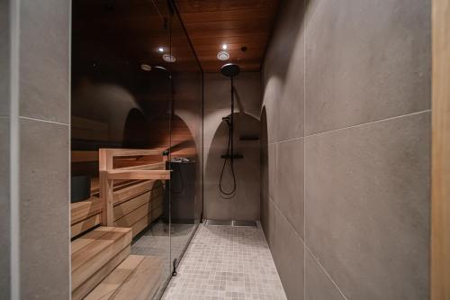 a bathroom with a shower with a glass wall at Levillas Lingonberry D26 in Levi