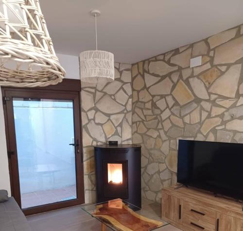 een woonkamer met open haard en tv bij La Casita in Tejadillos