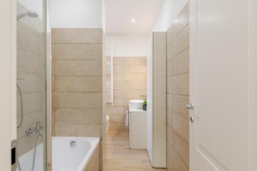 a bathroom with a white tub and a sink at Smart Flat - Easy Milan Link in Cinisello Balsamo