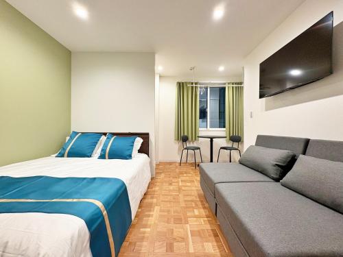 a bedroom with a bed and a couch at 東邦花咲ホテル in Yokohama