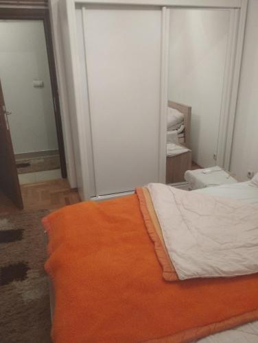 a bedroom with a bed with an orange blanket at APARTMENT, PLJEVLJA, NEW BUILDING 71 m2 in Pljevlja