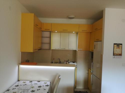 a kitchen with yellow cabinets and a sink at APARTMENT, PLJEVLJA, NEW BUILDING 71 m2 in Pljevlja