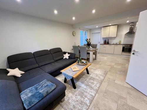 een woonkamer met een blauwe bank en een tafel bij Ferienwohnung auf dem Berg in Bad Bentheim