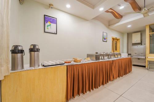 una cucina con un lungo bancone con cibo sopra di Treebo Akshaya Palace Inn a Mysore