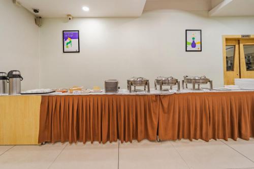 un lungo tavolo in una stanza con tavoli e sedie di Treebo Akshaya Palace Inn a Mysore