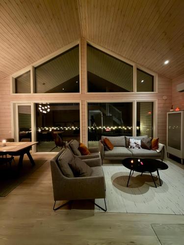 ein Wohnzimmer mit zwei Sofas und einem Tisch in der Unterkunft Villa Iiris - Peaceful Lapland Villa Surrounded by Nature in Äkäslompolo