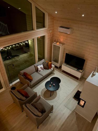 ein Wohnzimmer mit Sofa und Fernseher in der Unterkunft Villa Iiris - Peaceful Lapland Villa Surrounded by Nature in Äkäslompolo