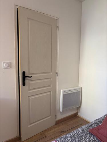 eine Tür in einem Zimmer neben einem Bett in der Unterkunft Chez Carla in Sisteron