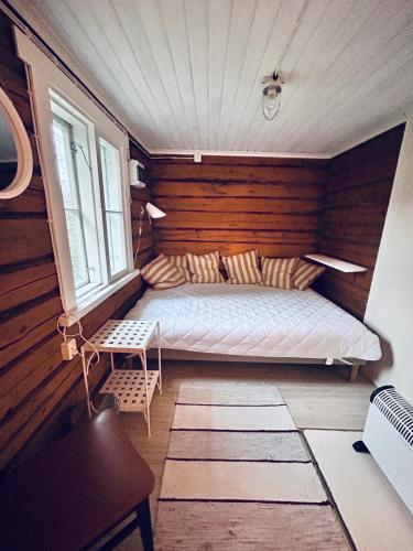 a bedroom with a bed in a room with wooden walls at Vääksyn Mummola in Vääksy