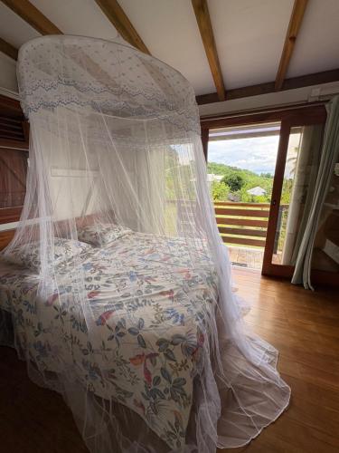 Bett mit Moskitonetz in einem Zimmer in der Unterkunft La cabane in Le Vauclin