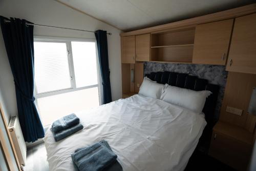 une chambre avec un lit blanc avec des serviettes dessus dans l'établissement No16 Caravan, home from home, à Angus