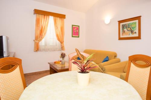 a living room with a table and chairs at Apartments Residence Astoria in Rab
