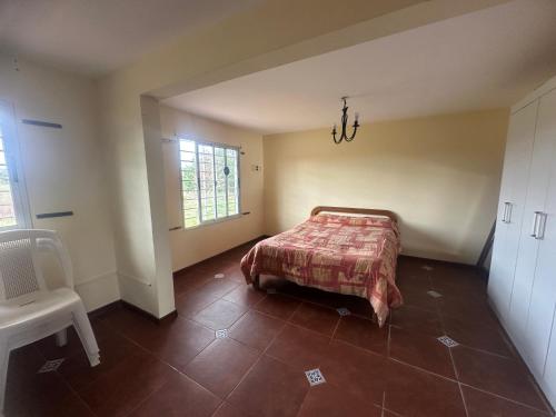 een slaapkamer met een bed en een stoel erin bij Casa de Campo in Minas