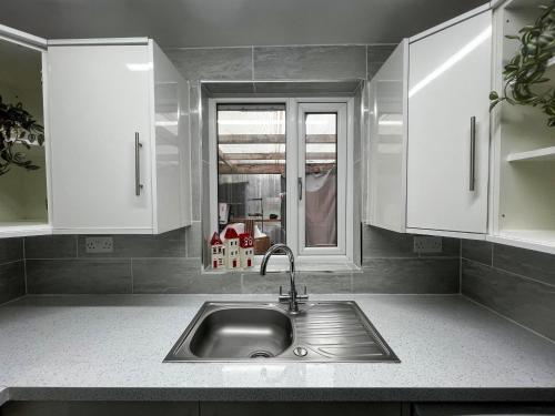 a kitchen counter with a sink and a window at Exquisite Bolton House, Garden Living, Parking, Sleeps 7 in Bolton