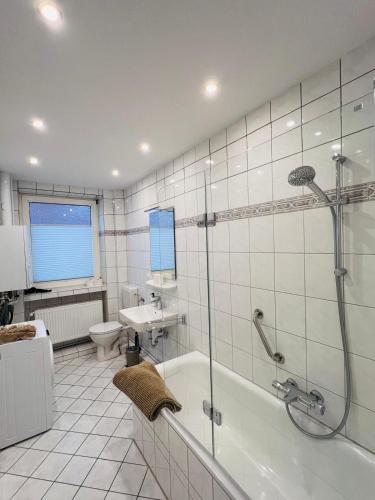 a bathroom with a shower and a tub and a sink at Marktblick in Esens