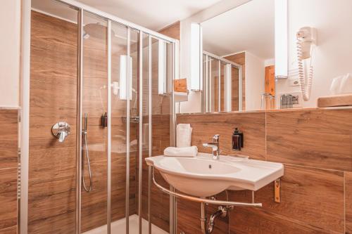 een badkamer met een wastafel en een douche bij Hotel Ansitz Kematen ***S in Collalbo