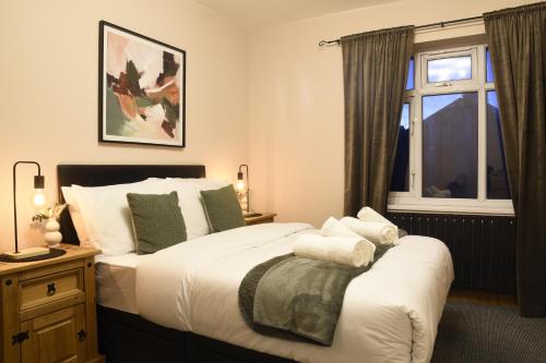a bedroom with a large bed and a window at Exquisite Bolton House, Garden Living, Parking, Sleeps 7 in Bolton