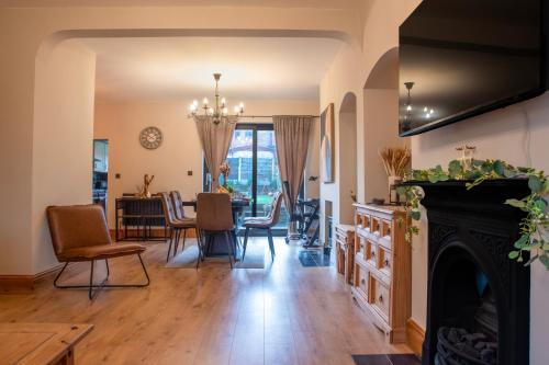 a living room with a fireplace and a dining room at Exquisite Bolton House, Garden Living, Parking, Sleeps 7 in Bolton