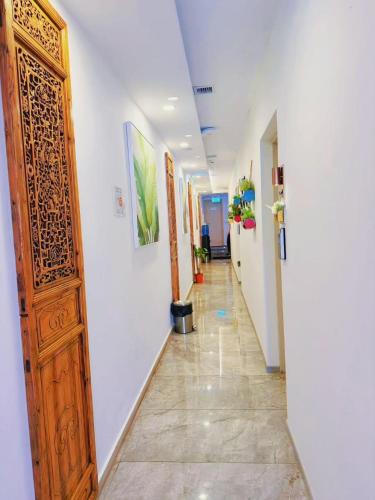a hallway with a wooden door and white walls at Coller Chinatown in Singapore