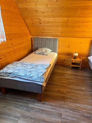 a bedroom with a bed in a wooden room at Domek Karkonosze in Wojcieszyce