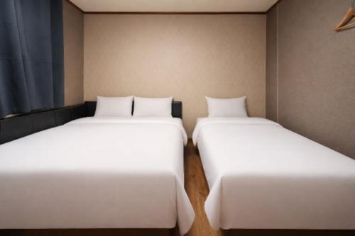 zwei Betten nebeneinander in einem Zimmer in der Unterkunft 귀빈모텔 in Donghae