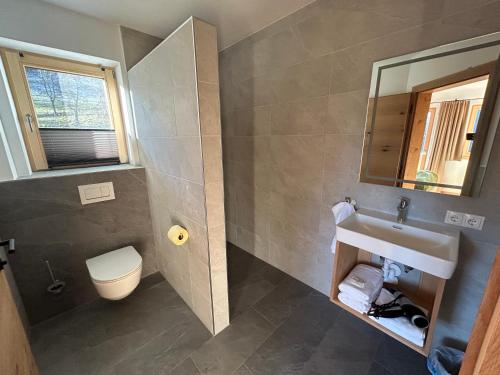 a bathroom with a sink and a toilet and a mirror at Wiererhof in Fügenberg