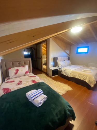 a bedroom with two beds with towels on them at Vila Loris in Voskopojë