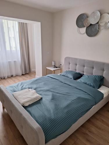 een slaapkamer met een groot bed met blauwe lakens bij Mateo rezidence in Bistriţa