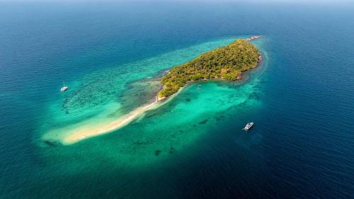 een eiland in de oceaan met boten in het water bij Yacht Charter Pattaya Ocean Marina Resort in Na Jomtien