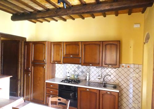 een keuken met houten kasten en een kookplaat met oven bij Torre Verde Acquapendente in Acquapendente