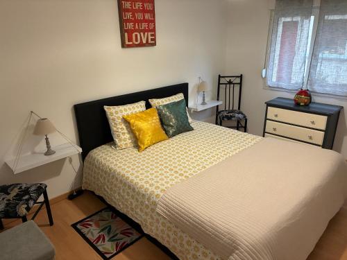 een slaapkamer met een groot bed met gele kussens bij Jolie, cozy, confortable maison de ville au calme à 5min du centre de Verdun, parking devant la maison in Belleville-sur-Meuse