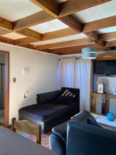 een woonkamer met een bank en een tv bij Cabaña sector centro Villarrica in Villarrica
