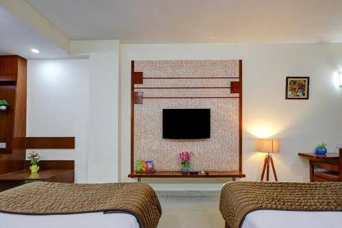 une chambre avec deux lits et une cheminée avec une télévision dans l'établissement Hotel B Stays, à Gurgaon